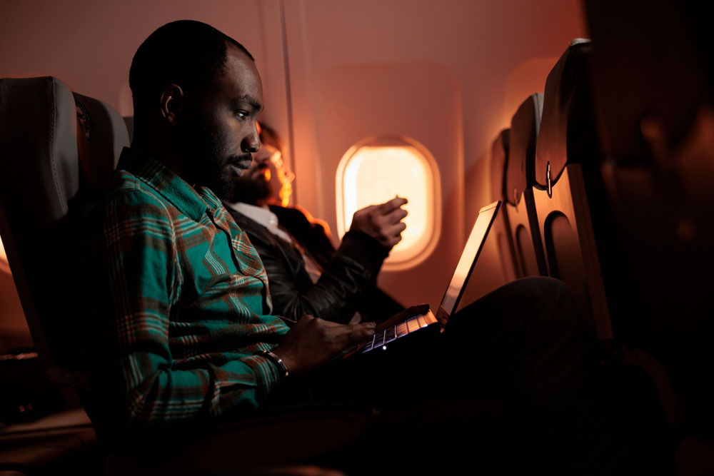 A happy passenger focusing on work onboard a Sentra Airways flight to Accra from Manchester